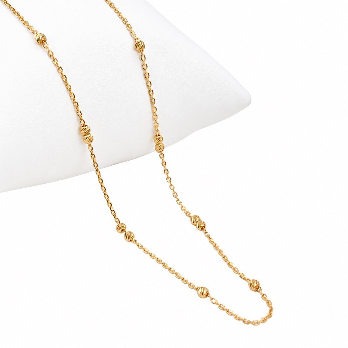Close-up of 2.4mm diamond cut gold beads on 22ct fine cable chain